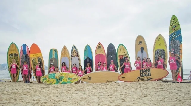 Grupo de egresadas con tablas de surf en la playa de Camboriú